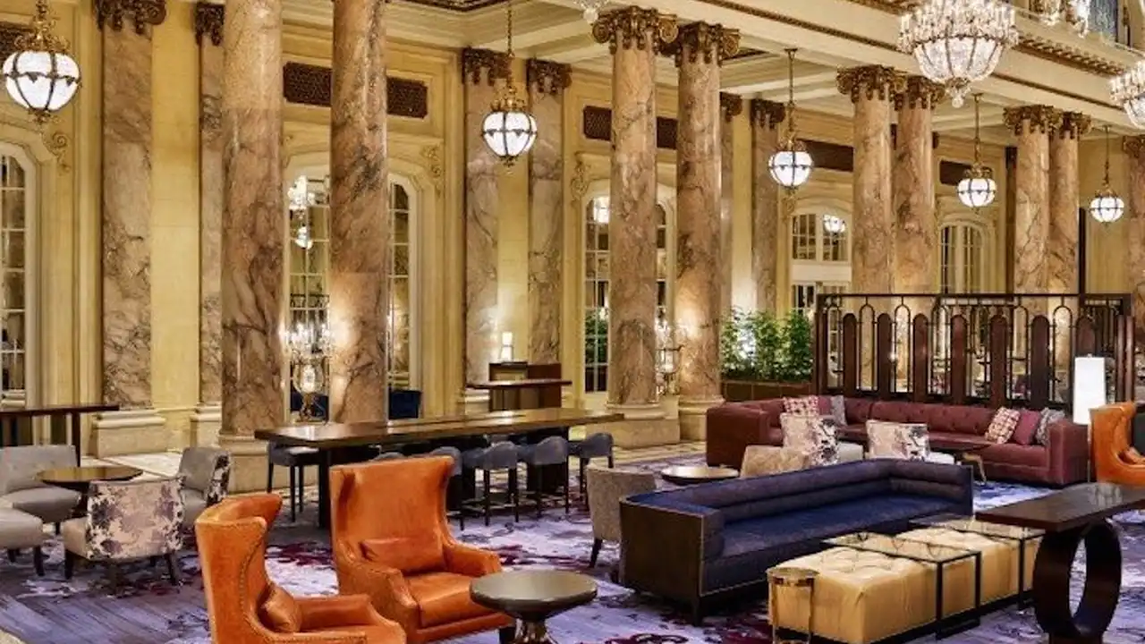 blue bowl of black bean beef tortilla soup on a board with cilantro and shredded cheese in background